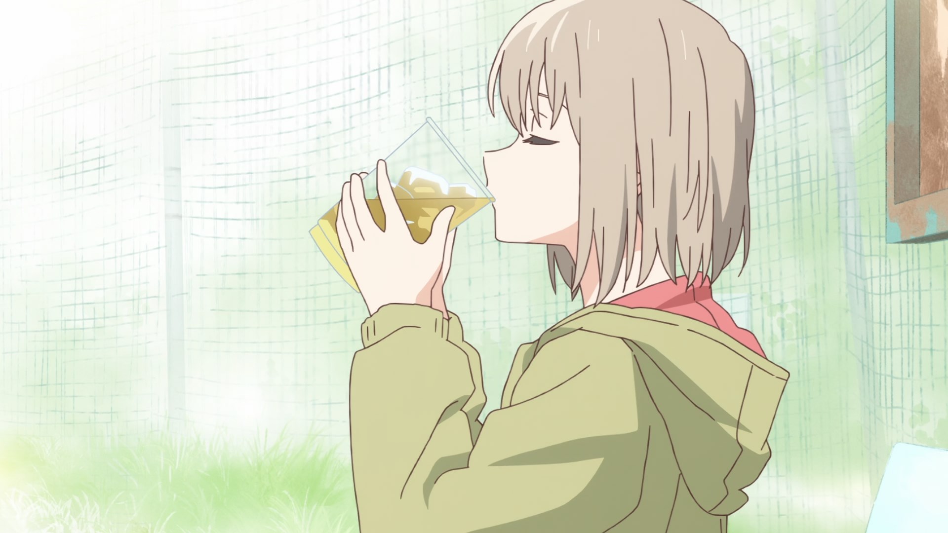 A small, young looking but actually old enough to drink, grey haired girl in a moss coloured hoodie lifting a glass to her face that is almost big enough for her to drown in
